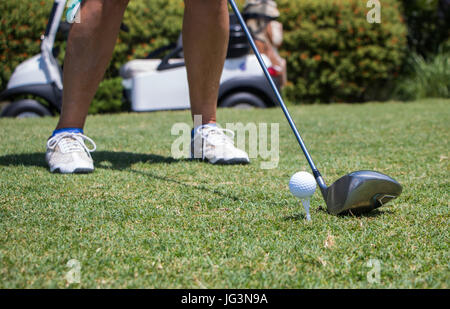 Il Golfer di colpire la pallina da golf tee off Foto Stock
