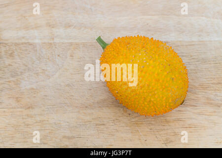 Gac frutta o Baby Jackfruit su sfondo di legno. Foto Stock