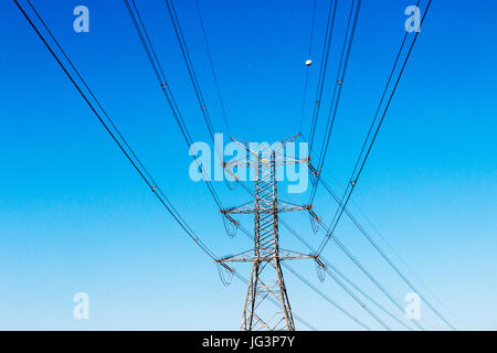 Close up of electric pylons and powerlines against clear blue sky in South Africa Foto Stock