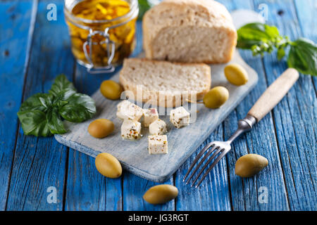 Marinata di formaggio di capra con olio d'oliva e basilico Foto Stock