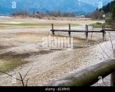 Vista del abbandonati lago Forggen con dietro di essa giacente Schwangau presso Fuessen / Bavaria con piede legno in primo piano. Il Forggensee viene alimentato da Foto Stock