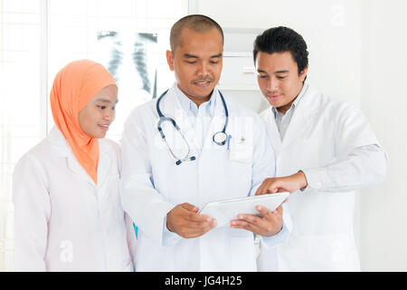 Team di medici e infermieri in riunione e cooperanti a discutere di diagnosticare. Sud-est asiatico medici musulmani. Foto Stock
