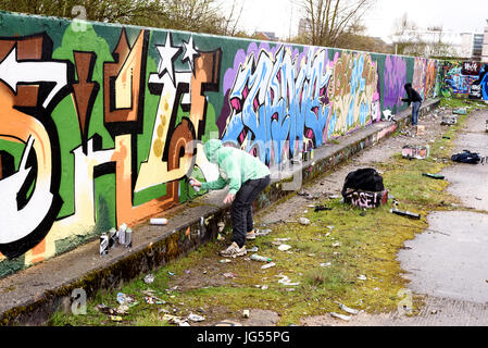 CHELMSFORD, INGHILTERRA 22ND MARZO 2017 -artisti di graffiti lavorando su una parete pubblica uno spruzzo di vernice per creare arte urbana Le pareti sono gratuiti per tutti per la verniciatura Foto Stock
