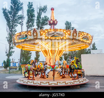 MAMAIA, Romania - 17 giugno 2015. Colori vibranti giostra con luci e cavalli, vicino all'aperto vicino spiaggia, mare. Foto Stock