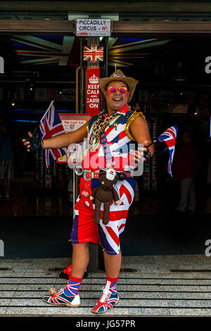 Un uomo in un Unione Jack Costume attira i clienti nella Cool Britannia Negozio di souvenir, Piccadilly Circus a Londra, Inghilterra Foto Stock