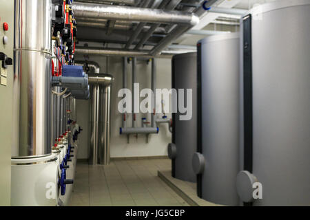 Stufe di riscaldamento e il tubo di infrastrutture nella sala caldaie Foto Stock