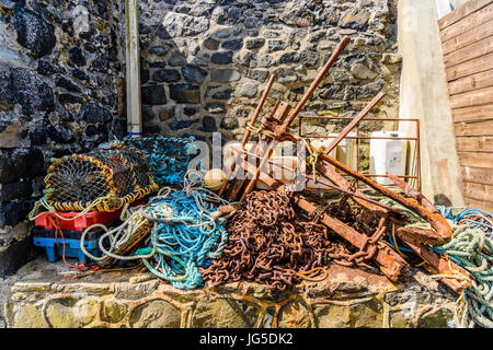 Catene, funi, aragosta gabbie e altre attrezzature da pesca a un vecchio porto. Foto Stock