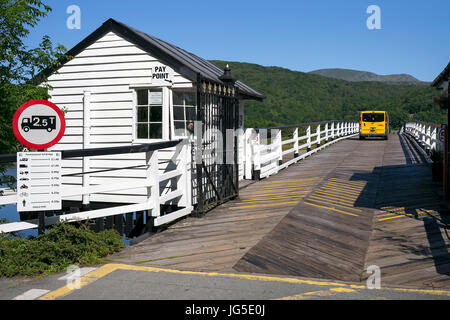 Un giallo tourer van tenendo il taglio corto attraverso la Mawddach Estuary in Penmaenpool, Dolgellau Galles, Regno Unito Foto Stock