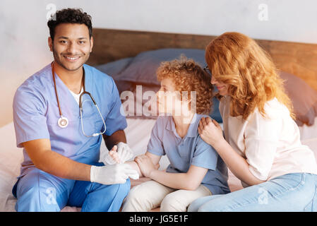 Piacere positivo lavoratore medico trattare ferito alla mano Foto Stock