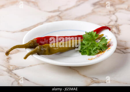 Decapato verde e rosso e salsiccia per pizza pepe nella piastra sulla tavola con prezzemolo Foto Stock