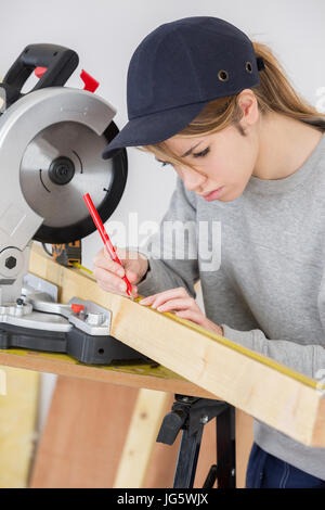 Falegname femmina di legno di misurazione con scala in officina Foto Stock