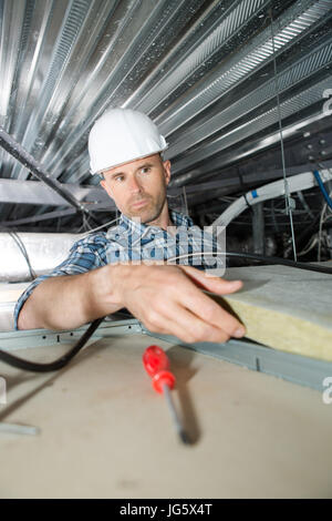 Copritetti builder lavoratore installazione tetto materiale di isolamento Foto Stock