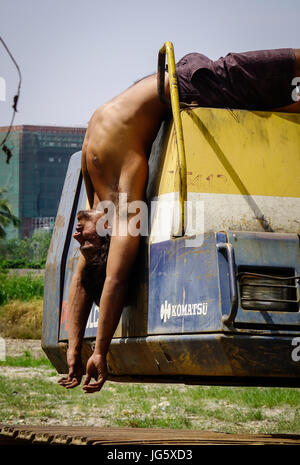 Delhi, India - Mar 9, 2017. Un giovane lavoratore facendo esercizio sul bulldozer a Delhi, India. Delhi è la quinta città più popolosa del mondo e la Foto Stock