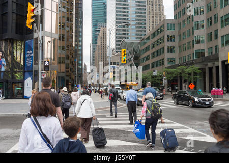 Toronto, Canada - 26 Giugno 2017: una folla di persone che attraversano Front Street nel centro di Toronto Foto Stock