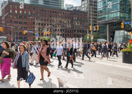 Toronto, Canada - 26 Giugno 2017: una folla di persone che attraversano Front Street nel centro di Toronto Foto Stock