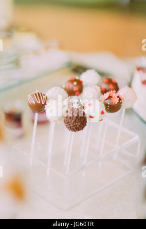 Bella chocolade lollipop decorata con cuori rossi, le linee bianche e fiori Foto Stock