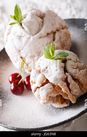 Torta di Natale snowball decorate con menta fresca e le ciliegie su una piastra closeup verticale. Foto Stock