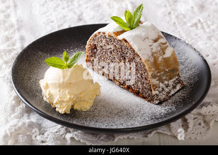 Tagliate a fette il papavero strudel con gelato alla vaniglia close-up su una piastra orizzontale. Foto Stock