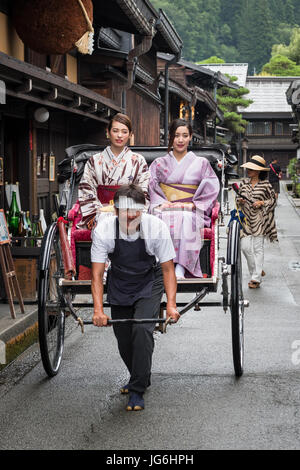 Geisha in abbigliamento tradizionale utilizzando tradizionale giapponese del trasporto pubblico, la potenza umana risciò. Takayama e Giappone. Foto Stock