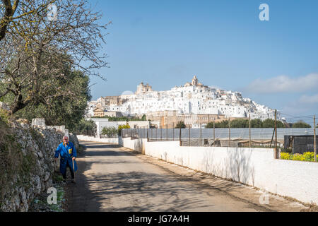 Ostuni, Italia - 27 Febbraio 2017: Bella Ostuni con anziani uomo a camminare sulla strada Foto Stock