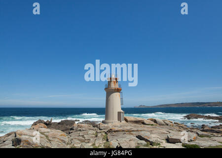 Faro de Camariñas Muxía (Faro) noto anche come il Faro de Punta da Barca (Faro sulla punta da Barca) sulla costa dell'Oceano Atlantico, conosciuta come la Costa de la Muerte (Costa della Morte), vicino alla città di Camariñas in Galizia, Spagna. Cabo Vilán è visto in background. Foto Stock