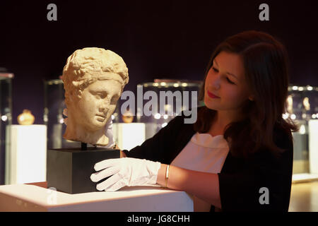 Londra, Regno Unito. 4 Luglio, 2017. Un Photocall ha avuto luogo prima dell'Antichità Bonhams vendita giovedì. Un marmo romana TESTA DI SATIRO risalente alla fine del 1st-inizi II secolo A.D.rivolti verso il basso e alla sua sinistra, il suo sguardo sereno e il suo spessore, serrature ondulata legato in una ampia filetto e coronata da una ghirlanda di bacche, ha sottolineato la sua capra orecchie emergente al di sotto, 25.4cm alto.Credit: Keith Larby/Alamy Live News Foto Stock