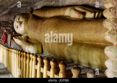 Buddista monaco novizio / little monk / giovane monaco culto bella grande Buddha reclinato statua nella grotta Phowintaung Monywa Myanmar Foto Stock