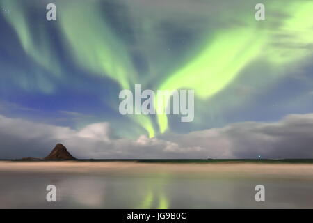 Luci verdi-aurora boreale illumina la spiaggia SW.del villaggio Bleik e Bleiksoya isola più grande puffin resort in Norvegia su un vento forte la notte. Anden Foto Stock