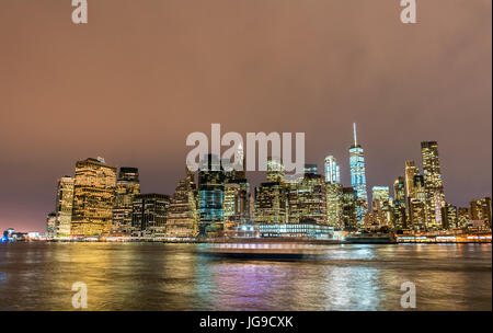 La parte inferiore di Manhattan di notte visto da Brooklyn Foto Stock
