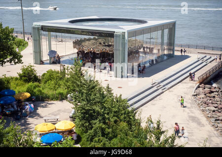 I visitatori di Ponte di Brooklyn Park godetevi Jane's giostra di domenica 2 luglio 2, 2017. La giostra storica è stata originariamente realizzata nel 1922 ed è stato restaurato da Jane Walentas, iniziando nel 1984 con l'intenzione di collocare in Ponte di Brooklyn Park. Il padiglione di alloggiamento della giostra storica è stato progettato dall'architetto Jean Nouvel. (© Richard B. Levine) Foto Stock