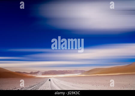 Ciclista solitario che viaggiano attraverso la parte remota del sud dell'Altiplano, Bolivia Foto Stock