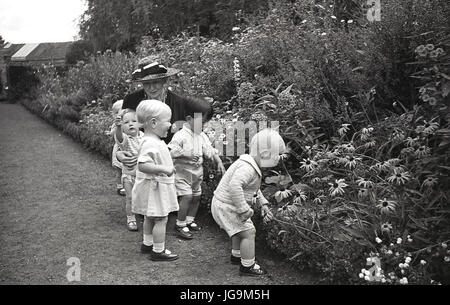 1940, in Inghilterra, in tempo di guerra, nella motivazione di Stanstead Hall, casa di lady Butler ( Sydney Courtauld) moglie del maggiordomo di Rab, politico conservatore, alcuni dei bambini sfollati da Londra guardare i fiori. Foto Stock