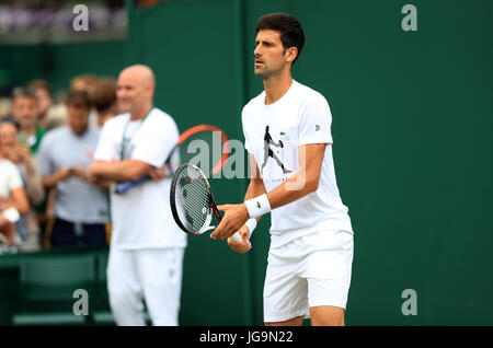 Novak Djokovic practice guardato in pullman Andre Agassi del giorno due dei campionati di Wimbledon al All England Lawn Tennis e Croquet Club, Wimbledon. Foto Stock