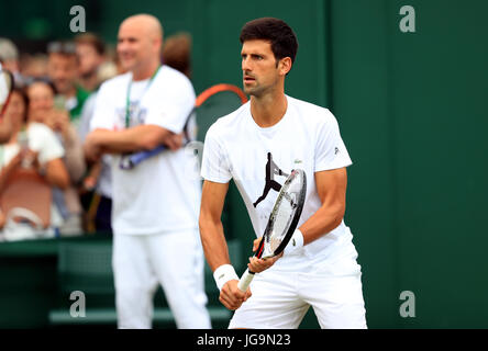 Novak Djokovic practice guardato in pullman Andre Agassi del giorno due dei campionati di Wimbledon al All England Lawn Tennis e Croquet Club, Wimbledon. Foto Stock