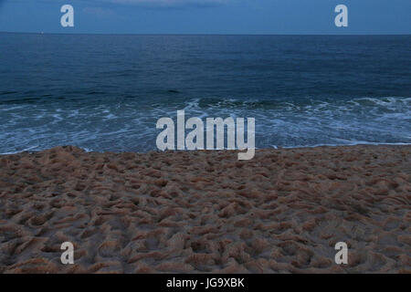 Twilight al mare con spiaggia di sabbia con impronte Foto Stock