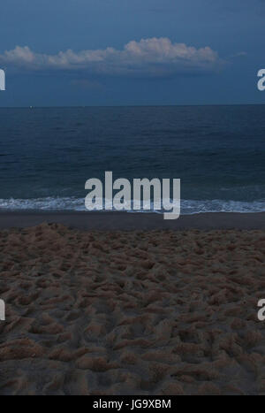 Twilight al mare con spiaggia di sabbia con impronte Foto Stock