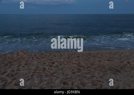 Twilight al mare con spiaggia di sabbia con impronte Foto Stock