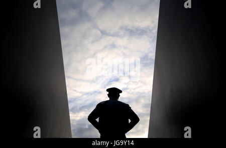 Un membro delle forze armate guardie un ingresso a corte il giorno due dei campionati di Wimbledon al All England Lawn Tennis e Croquet Club, Wimbledon. Foto Stock