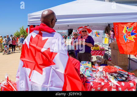 Uomo Che Indossa La Bandiera Canadese, Canada Day, Village Of Steveston, Richmond, British Columbia, Canada. Foto Stock