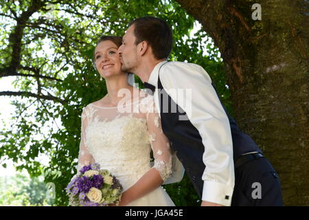 Lo sposo in amore è baciare la sposa Foto Stock