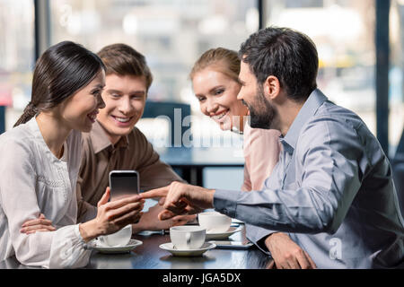 Il team di business in una riunione per discutere di un progetto con lo smartphone nel cafe, pranzo di lavoro concept Foto Stock