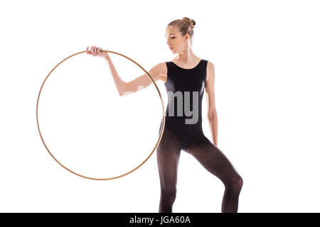 Attraente giovani sportive nel body facendo ginnastica ritmica esercizio con hoop Foto Stock