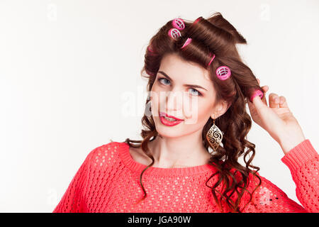 Ragazza con arricciacapelli rende lo stile dei capelli Foto Stock