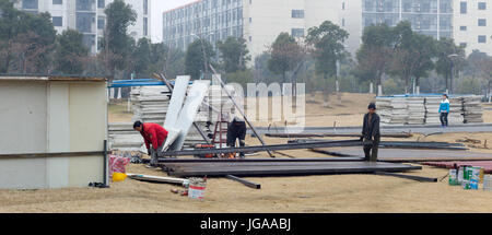 Angolo di ferro le barre da tagliare ed eretto in composito di supporto di pannelli di recinzione (impilati sul terreno) intorno al cantiere nei pressi di Han Lin Centro di quartiere. Suzhou, Foto Stock