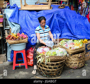 Bali, Indonesia - Apr 21, 2016. Una donna Vendita fiori a pregare presso il Mercato Centrale di Bali, Indonesia. Bali è una destinazione turistica popolare, che ha Foto Stock