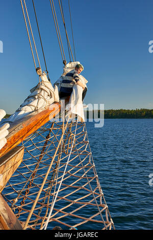 Astrid (Finlandia) TS 488 Gaff Ketch in legno barca a vela 1947 - membro di equipaggio avvolgifiocco e stivare le vele di prua Foto Stock