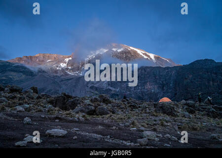 Sole di mattina si illumina kibo e tenda di escursionisti, il Monte Kilimanjaro, Tanzania Foto Stock