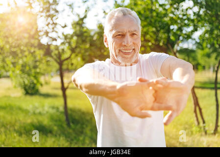 Felice l'uomo in pensione facendo esercizi di stretching Foto Stock