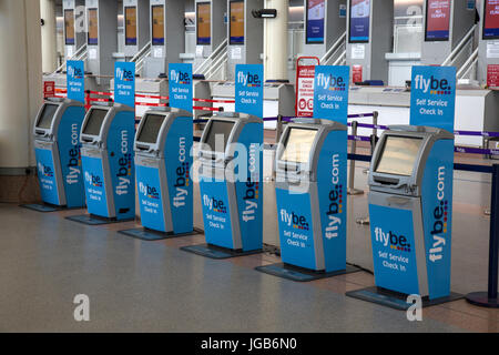 Una fila di Flybe self service macchine di check-in presso l'aeroporto di Jersey nel British Isole del Canale. Foto Stock