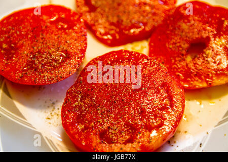 Una piastra di fettine di pomodori cresciuti in casa con sale e pepe Foto Stock